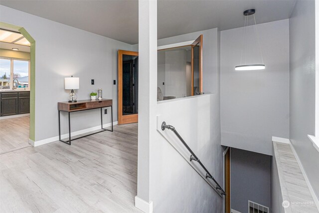 staircase featuring hardwood / wood-style floors and sink