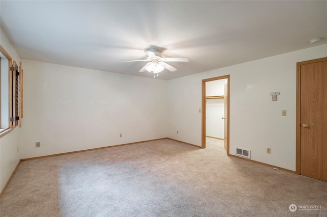 carpeted spare room with ceiling fan