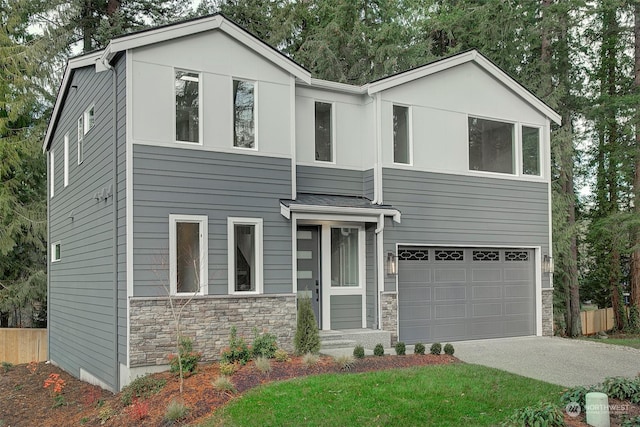 view of front of home featuring a garage, stone siding, driveway, and fence