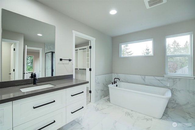 bathroom with visible vents, recessed lighting, a freestanding tub, marble finish floor, and vanity