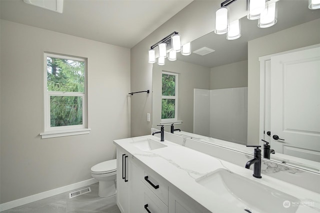 full bath with toilet, baseboards, visible vents, and a sink