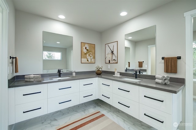 full bathroom featuring double vanity, recessed lighting, marble finish floor, and a sink