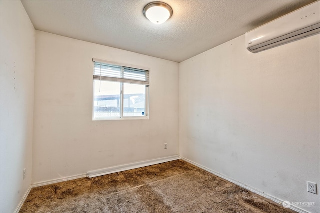 carpeted spare room featuring a textured ceiling and a wall mounted air conditioner