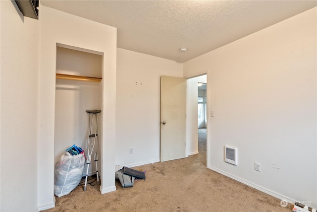 unfurnished bedroom featuring light carpet, a closet, and a textured ceiling