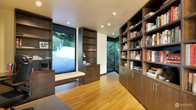 home office featuring floor to ceiling windows, recessed lighting, and light wood-style floors