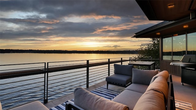 balcony at dusk with a water view, grilling area, and outdoor lounge area