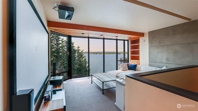 carpeted bedroom with a wall of windows, a water view, and access to exterior