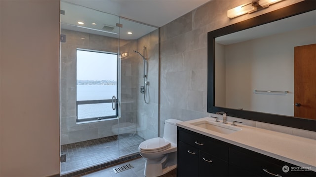 bathroom with vanity, tile patterned flooring, toilet, tile walls, and an enclosed shower