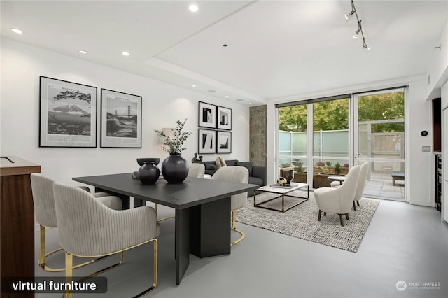 interior space with a wall of windows, rail lighting, and concrete floors