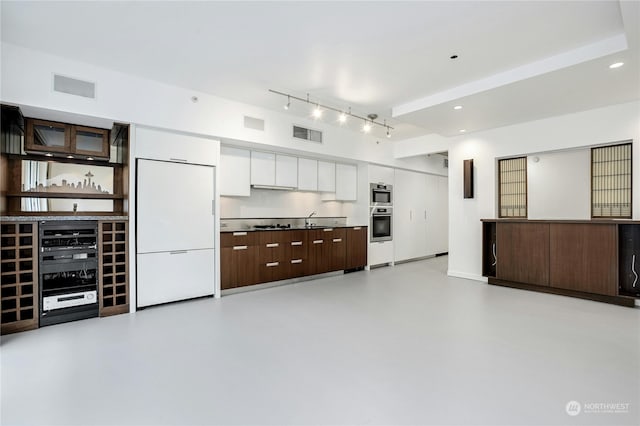 kitchen with white cabinets, oven, dark brown cabinetry, and white built in refrigerator