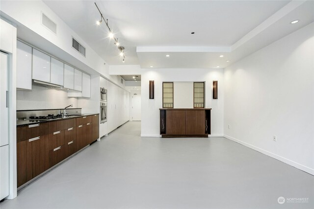 kitchen featuring white cabinets, dark brown cabinetry, sink, and extractor fan