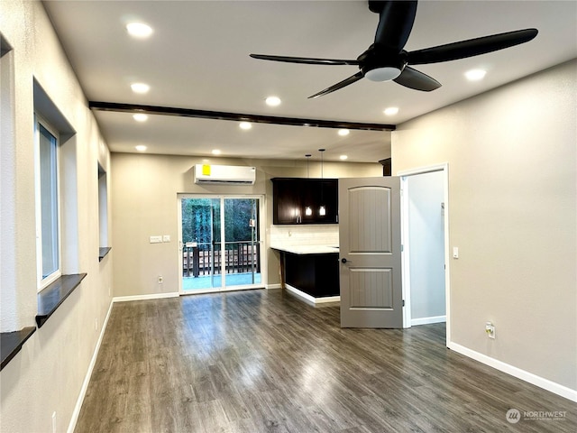 unfurnished living room featuring dark hardwood / wood-style flooring, a wall unit AC, and ceiling fan