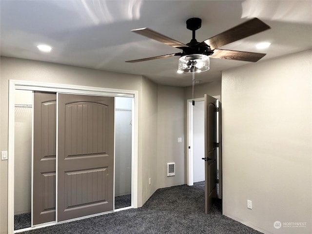 unfurnished bedroom with a closet, ceiling fan, and dark colored carpet