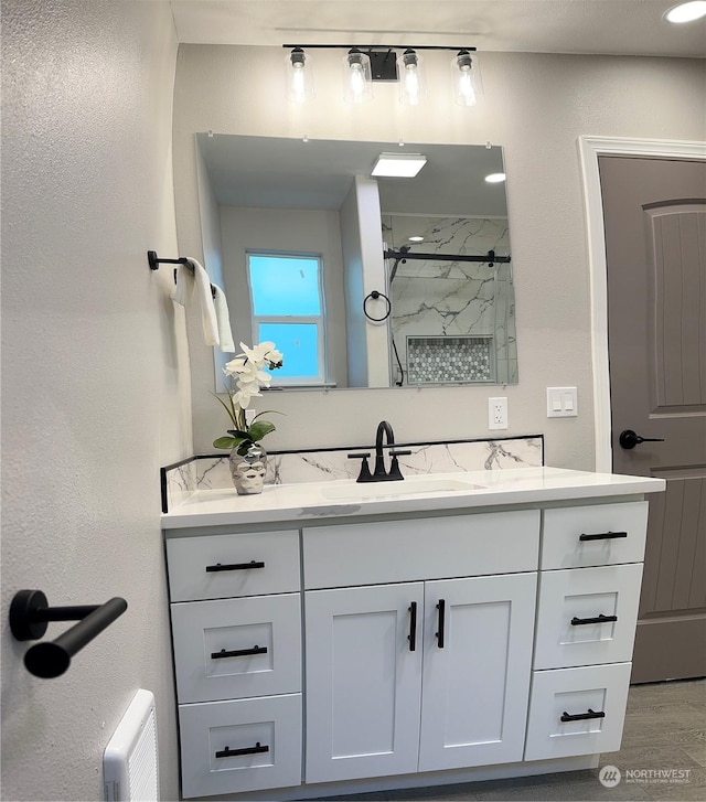 bathroom with walk in shower and vanity