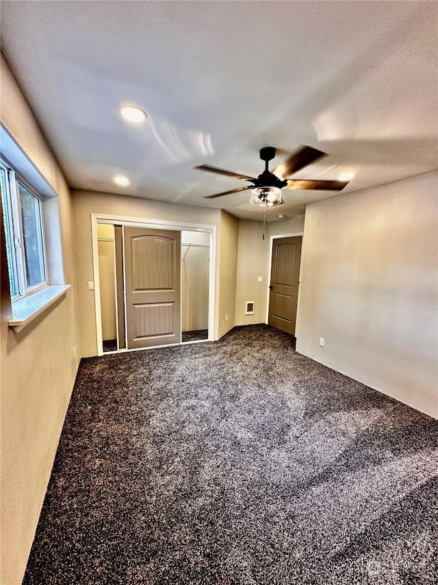 unfurnished bedroom with ceiling fan, carpet flooring, a textured ceiling, and a closet