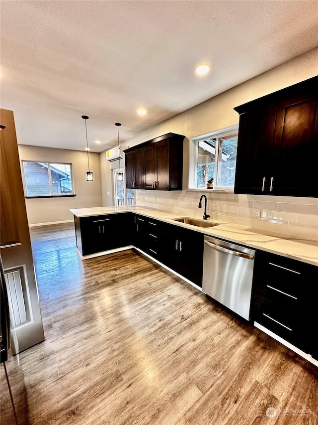 kitchen featuring sink, hanging light fixtures, light wood-type flooring, dishwasher, and a wealth of natural light