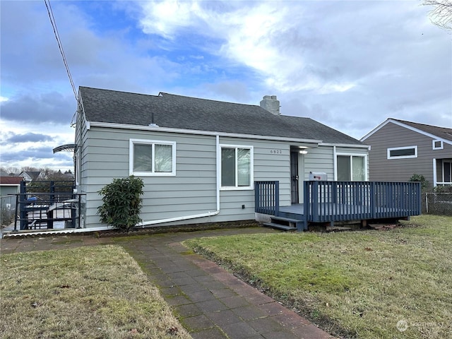 back of house with a wooden deck and a yard