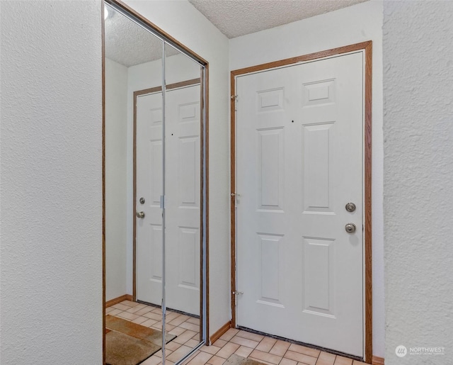 interior space with a textured wall, baseboards, and a textured ceiling