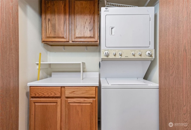 laundry room with cabinet space and stacked washer and dryer