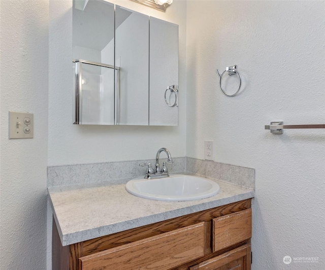 bathroom with an enclosed shower and vanity