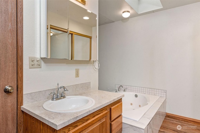 bathroom featuring a tub with jets and vanity