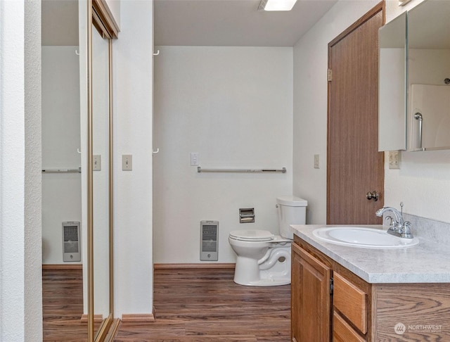 full bath featuring vanity, toilet, wood finished floors, and heating unit