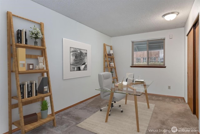 carpeted office with baseboards and a textured ceiling