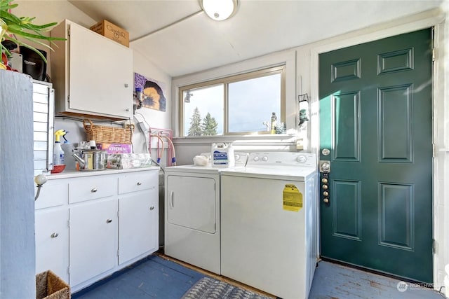 clothes washing area featuring washer and clothes dryer and cabinets