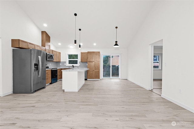 kitchen featuring pendant lighting, a center island, light wood-type flooring, and stainless steel appliances