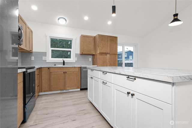 kitchen featuring white cabinetry, sink, pendant lighting, decorative backsplash, and appliances with stainless steel finishes