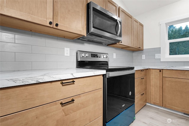 kitchen with light stone counters, black range with electric stovetop, light hardwood / wood-style flooring, and tasteful backsplash