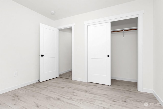 unfurnished bedroom with a closet and light hardwood / wood-style flooring