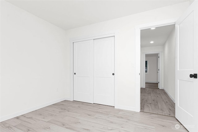 unfurnished bedroom with a closet and light hardwood / wood-style flooring