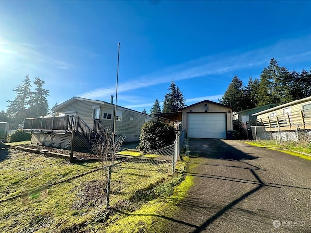 view of side of property with an outbuilding, a garage, and a wooden deck