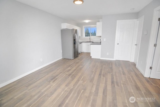 unfurnished living room with hardwood / wood-style flooring and sink