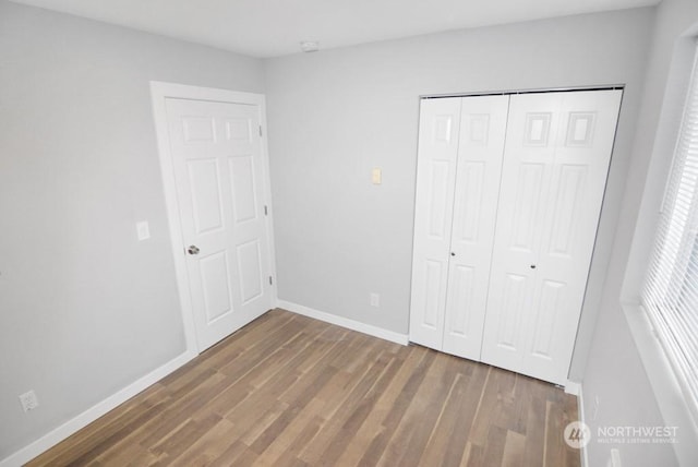 unfurnished bedroom featuring dark hardwood / wood-style flooring and a closet