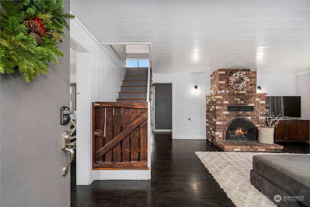 living room with dark wood-type flooring and a brick fireplace