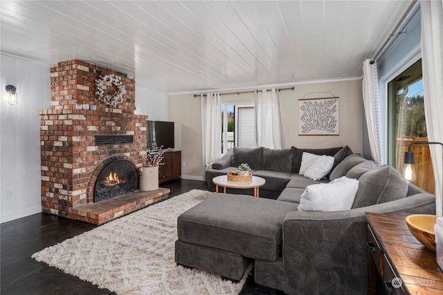 living room with a fireplace, dark hardwood / wood-style floors, and ornamental molding