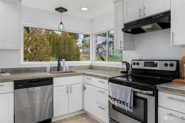 kitchen featuring white cabinets, sink, decorative light fixtures, light tile patterned flooring, and stainless steel appliances