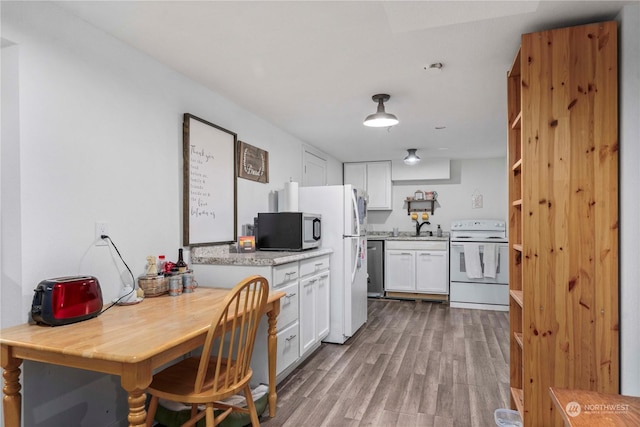 kitchen featuring appliances with stainless steel finishes, light wood-type flooring, white cabinetry, and sink