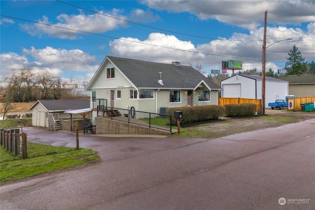 view of front of home with a garage and an outbuilding