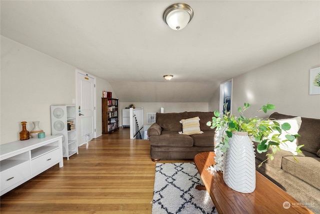 living room featuring wood-type flooring and vaulted ceiling