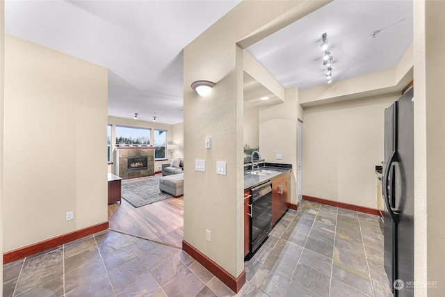 kitchen with sink, track lighting, and black appliances