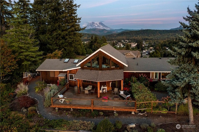 back house at dusk featuring a deck with mountain view