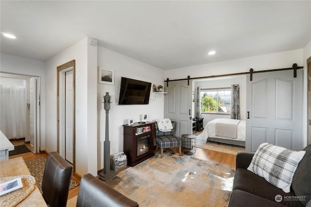 bedroom featuring wood-type flooring and a barn door