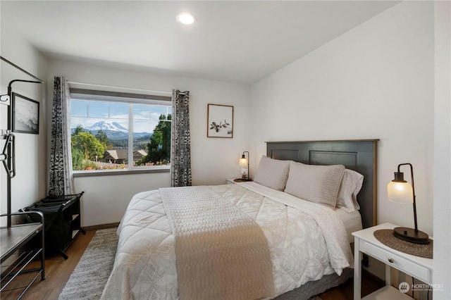 bedroom with a mountain view and hardwood / wood-style floors