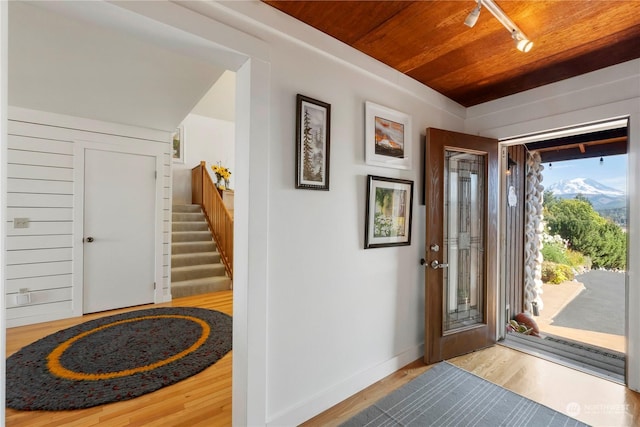 foyer featuring wood ceiling, track lighting, and light hardwood / wood-style floors