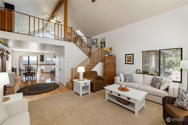 living room featuring a wealth of natural light, high vaulted ceiling, and light hardwood / wood-style floors