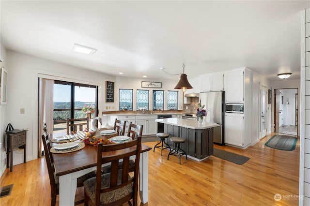 dining room with light hardwood / wood-style flooring and sink