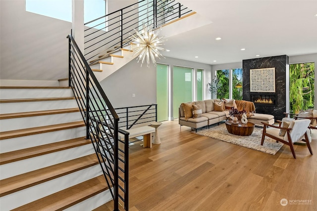 living room featuring a fireplace, hardwood / wood-style flooring, an inviting chandelier, and a wealth of natural light